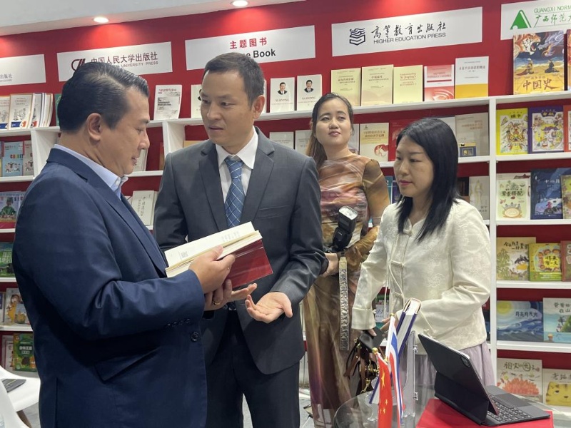 泰國書(shū)商和出版商協(xié)會(huì )主席蘇維奇（左一）在翻閱《近鏡頭：溫暖的瞬間》。（盧雯 攝）jpg_副本.jpg