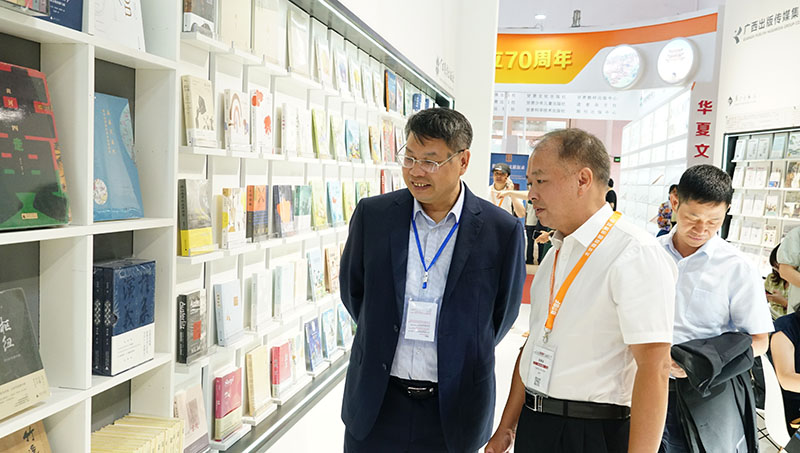 集團公司黨委書(shū)記、董事長(cháng)張藝兵向校黨委副書(shū)記趙鐵詳細介紹出版社圖書(shū)（陳子鋒攝）.JPG